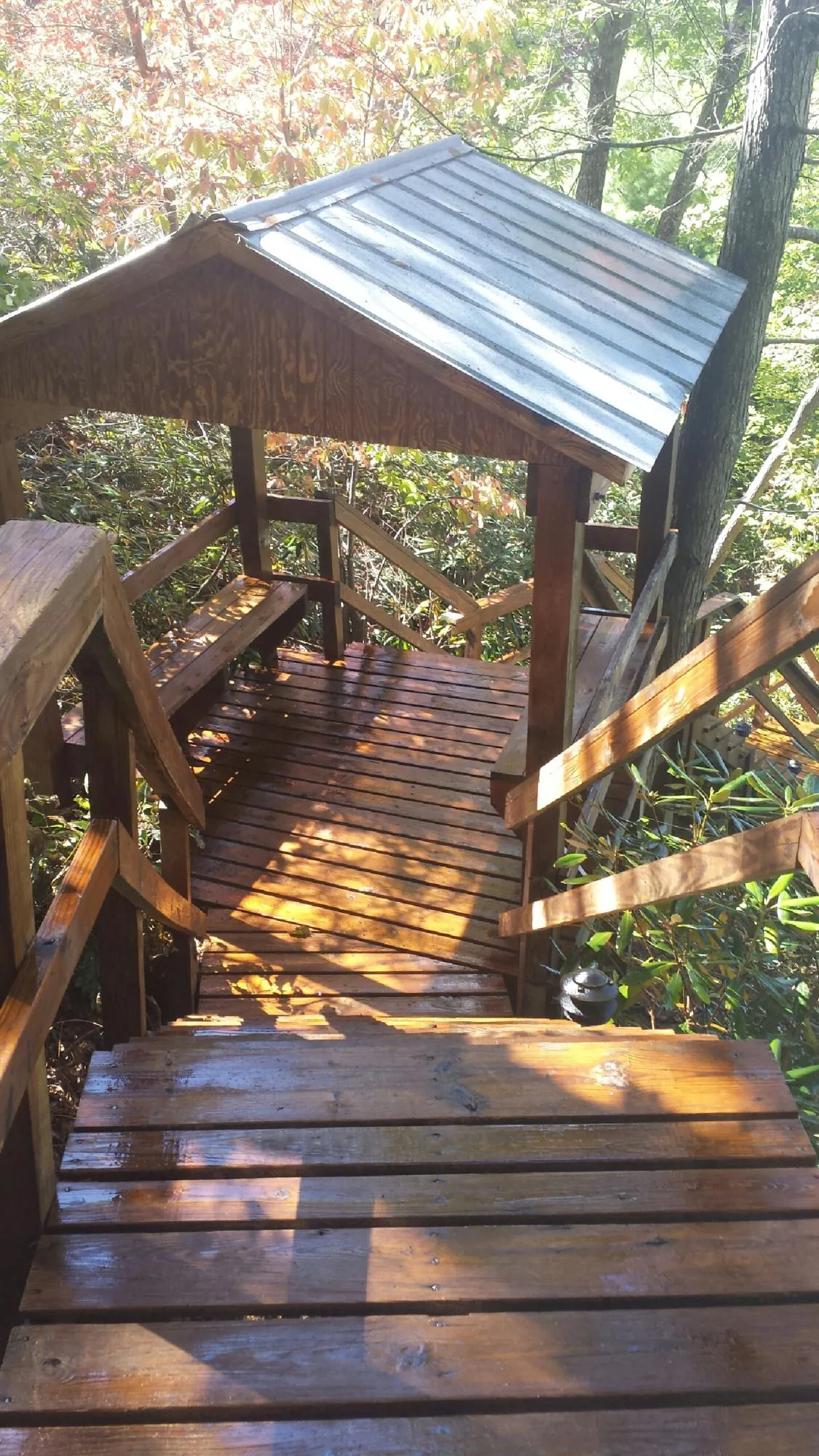 Freshly stained wood walkway and covered shelter with a metal roof in Hinton